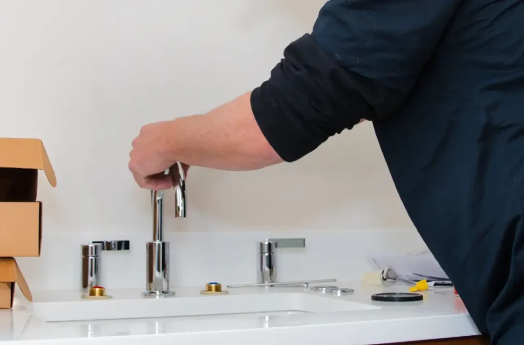 Person installing a bathroom faucet.