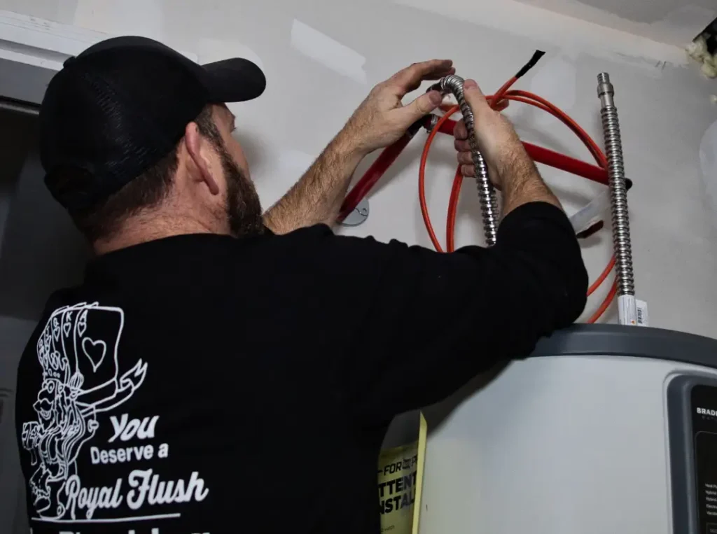 Plumber working on water heater connections