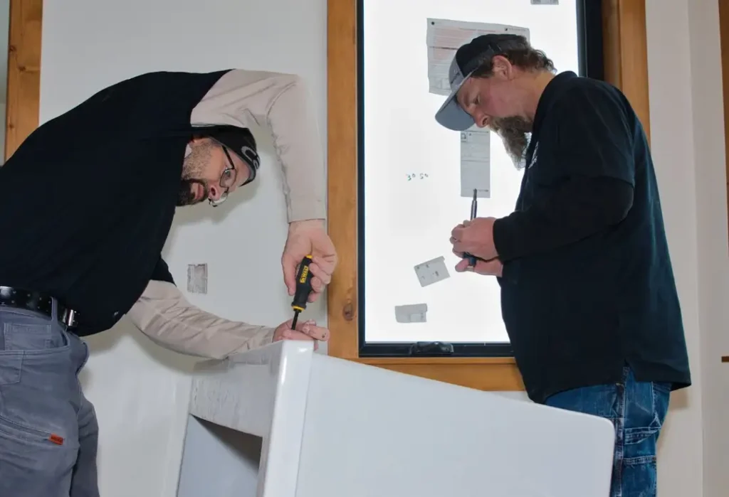 Two men working on plumbing installation.